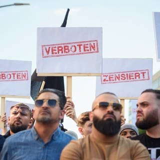 Demonstranten halten Schilder mit den Aufdrucken «Verboten» und «Zensiert» auf einer Kundgebung des islamistischen Netzwerks Muslim Interaktiv im Hamburger Stadtteil St. Georg in die Höhe.