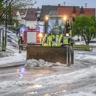 Einsatzkräfte der Feuerwehr räumen eine Straße. Es regnete in der Nacht im Südwesten und Westen Deutschlands heftig, aber anders als befürchtet hielten sich die Einsätze für Feuerwehr und Polizei in Grenzen.