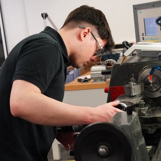Tjark Merker, Auszubildender zum Zerspanungsmechaniker, arbeitet an einer Drehmaschine in der Auszubildenden-Werkstatt des Schreibgeräteherstellers Montblanc. 