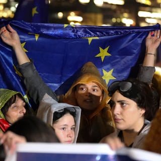 Demonstranten halten eine EU-Fahne während eines Protests gegen das sogenannte «russische Gesetz». Täglich finden Proteste gegen ein beabsichtigtes Gesetz statt, das nach Ansicht von Kritikern die Medienfreiheit einschränken und die Bewerbung des Landes zum Beitritt in die Europäische Union behindern würde.