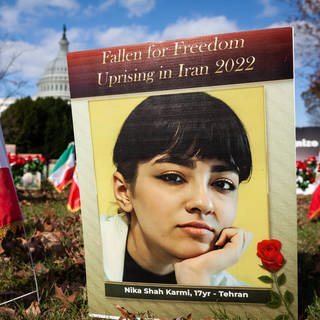 Memorial at US Capitol for Iranians killed in recent protests A photo of Nika Shah Karmi is one of hundreds of signs and flowers filling a lawn at the US Capitol, memorializing protesters killed in the 2019 and 2022 uprisings in Iran.  (Foto: IMAGO, Copyright: xAllisonxBaileyx originalFilename: bailey-memorial221117_npX6P.jpg)
