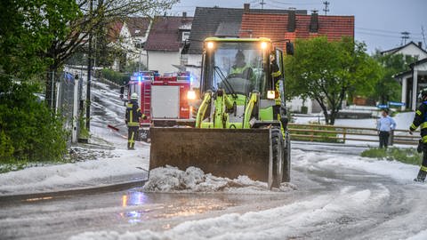 Einsatzkräfte der Feuerwehr räumen eine Straße. Es regnete in der Nacht im Südwesten und Westen Deutschlands heftig, aber anders als befürchtet hielten sich die Einsätze für Feuerwehr und Polizei in Grenzen.
