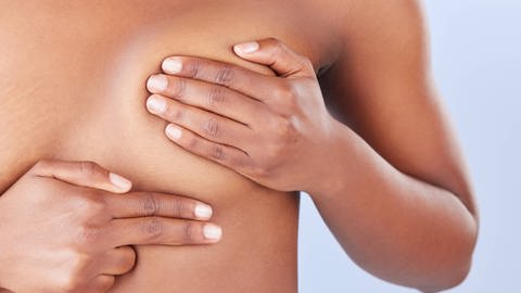 SYMBOLBILD: Eine Frau untersucht ihre Brust, ob sie Knoten findet, die auf Brustkrebs hindeuten können.