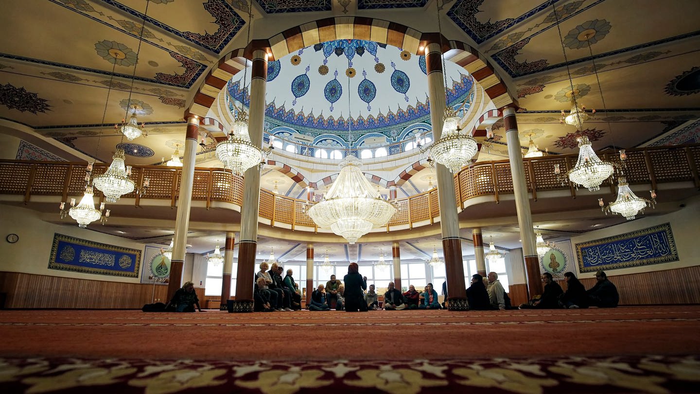 Besucher stehen am Tag der offenen Moschee während einer Führung in Mannheim in dem Gebetsraum der Yavuz-Sultan-Selim-Moschee. (Foto: dpa Bildfunk, picture alliance / dpa | Ronald Wittek)