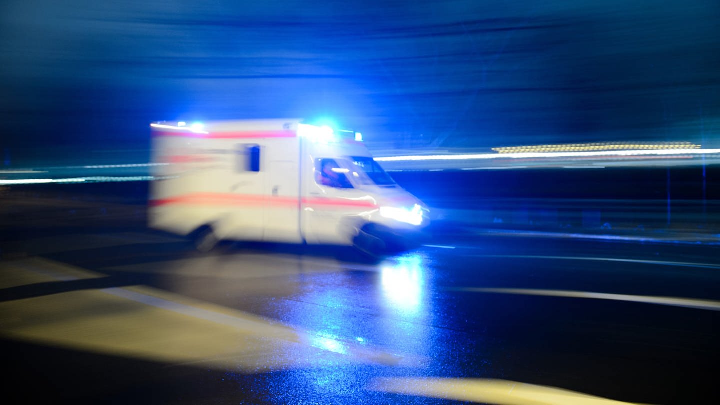 Ein Rettungswagen mit Blaulicht fährt durch eine Straße