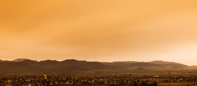 Mit Saharastaub angereicherte Luft aus Nordafrika weht über dem Rheintal und sorgt für rötlich verfärbtes Tageslicht. (Foto: dpa Bildfunk, picture alliance/dpa | Philipp von Ditfurth)