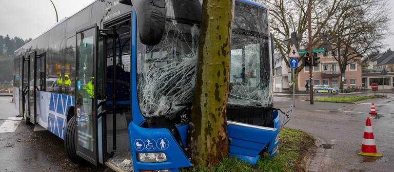 Ein Bus steht nach einem Unfall am Ende der Kaiser-Wilhelm-Brücke mit der Front an einem Baum. (Foto: dpa Bildfunk, picture alliance/dpa | Harald Tittel)