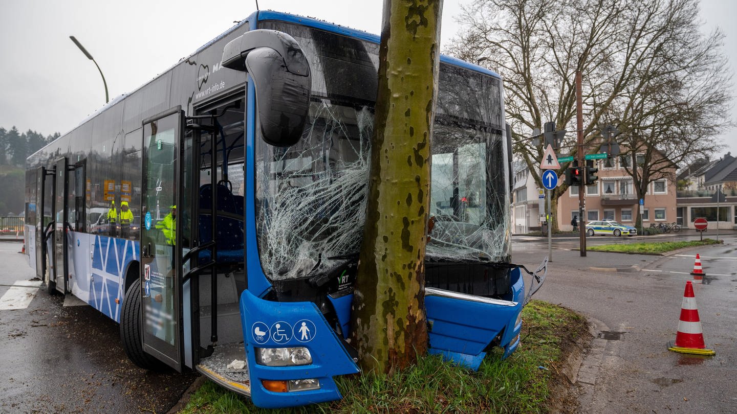 Ein Bus steht nach einem Unfall am Ende der Kaiser-Wilhelm-Brücke mit der Front an einem Baum.