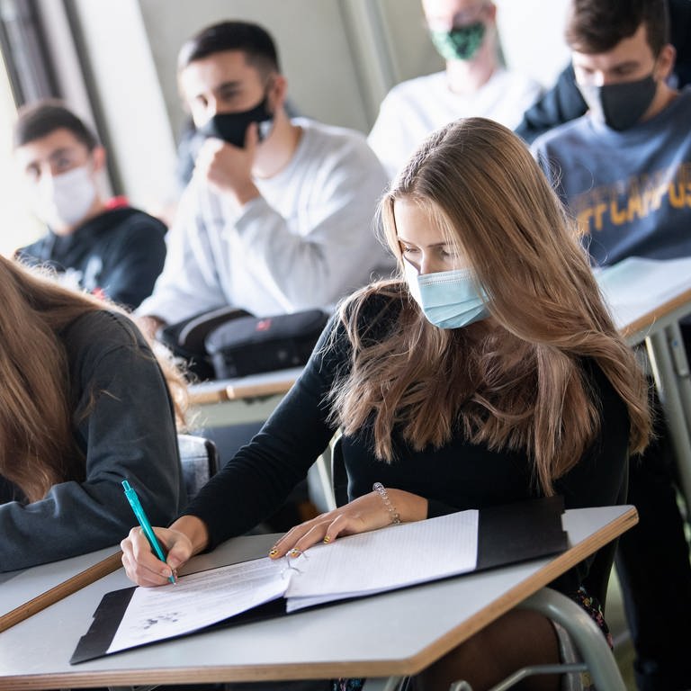 Schülerinnen und Schüler nehmen mit Mund- und Nasenschutz am Unterricht teil (Foto: dpa Bildfunk, picture alliance/dpa | Matthias Bal)