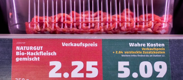 Ein Preisschild weist neben dem Verkaufspreis auch den «wahren Preis» in einem Supermarkt aus.  (Foto: dpa Bildfunk, picture alliance/dpa | Rolf Vennenbernd)