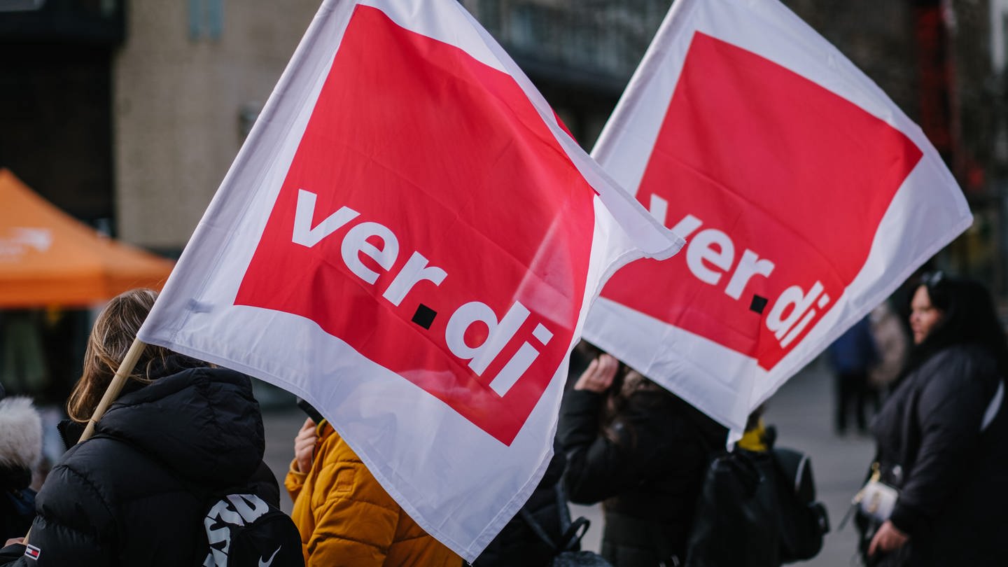 Beschäftigte der Sozial- und Erziehungsberufe demonstrieren mit Verdi-Fahnen in der Innenstadt.