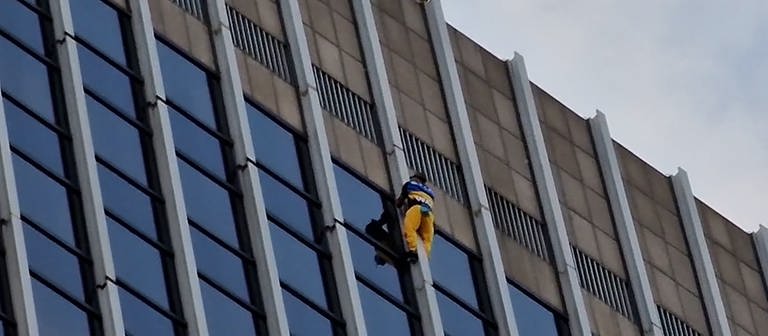 Mann klettert Turm hoch. Blau-gelb gekleidet. (Foto: dpa Bildfunk, picture alliance/dpa/5Vision Media | ---)