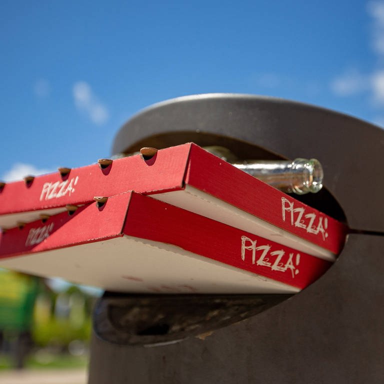 Mülleimer mit Pizzakarton und leeren Flaschen (Foto: dpa Bildfunk, IMAGO / Eibner)