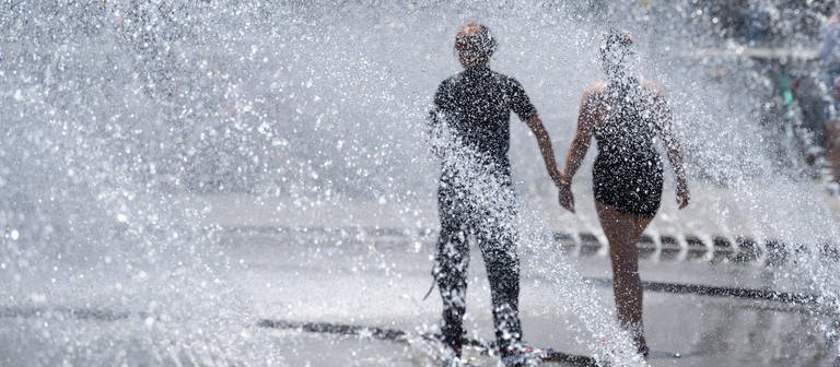 Zwei Jugendliche kühlen sich an einem Springbrunnen ab (Foto: dpa Bildfunk, picture alliance/dpa | Sven Hoppe)