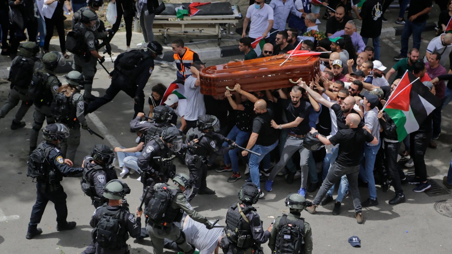 Israelische Polizisten stoßen mit palästinensischen Trauernden, die den Sarg der getöteten Al-Dschasira-Reporterin Abu Akle tragen, zusammen.
