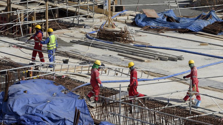 Gastarbeiter arbeiten auf einer Baustelle für die Fußball-WM 2022 in Katar. (Foto: IMAGO, IMAGO / MIS)