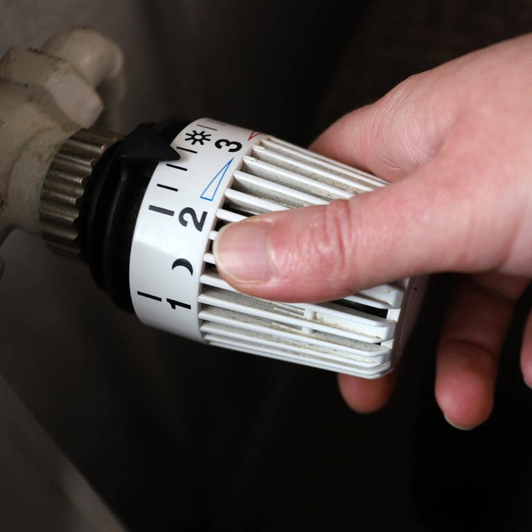 IMAGO  Rene Traut (Foto: IMAGO, Die Energiekosten steigen und steigen, Thermostatkopf an einem Heizkoerper mit Hand Symbolbild zum Thema Energiekosten)