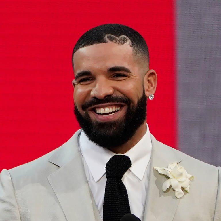 Drake, Rapper und R&B-Sänger, lächelt in weißem Anzug. (Foto: dpa Bildfunk, picture alliance/dpa/Invision/AP | Chris Pizzello)