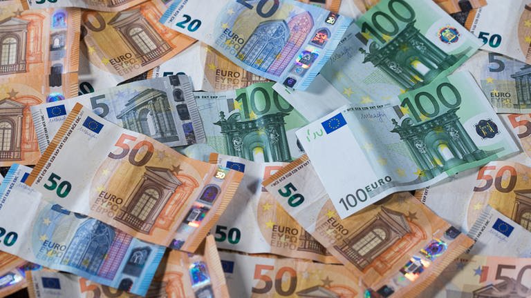 Verscheidene Euro-Geldscheine liegen auf einem Tisch.