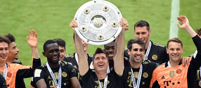 Robert Lewandowski vom FC Bayern München hält im Mai 2021 die Meisterschale hoch nach dem Sieg der Meisterschaft in der Fußball-Bundesliga. (Foto: dpa Bildfunk, picture alliance/dpa/dpa-Pool | Sven Hoppe)