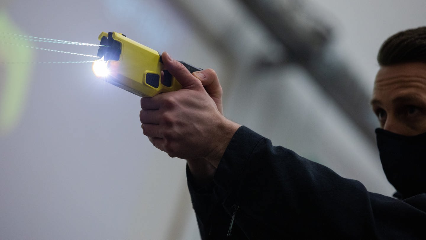 Ein Polizeibeamter demonstriert einen Schuss mit einem Distanzelektroimpulsgerät (DEIG oder auch Taser)