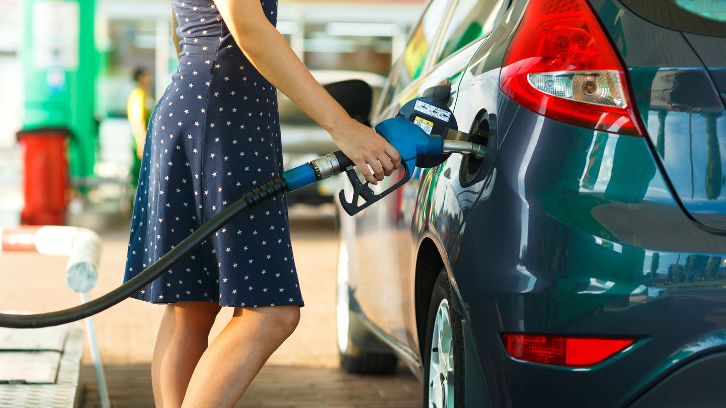 Woman refueling car at gas station model released