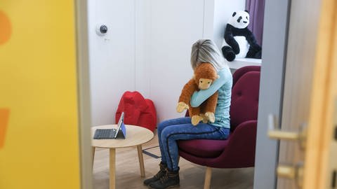 Eine Frau sitzt beispielhaft in einem Raum im Leipziger Childhood-Haus. (gestellte Szene) (Foto: dpa Bildfunk, picture alliance/dpa | Jan Woitas)