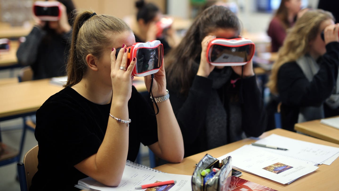 Schülerinnen arbeiten im Unterricht mit VR-Brillen.