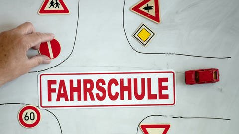 Ein Magnet mit der Aufschrift «Fahrschule» ist an einer Wandtafel mit verschiedenen Verkehrsymbolen zu sehen. (Foto: dpa Bildfunk, picture alliance/dpa | Swen Pförtner)