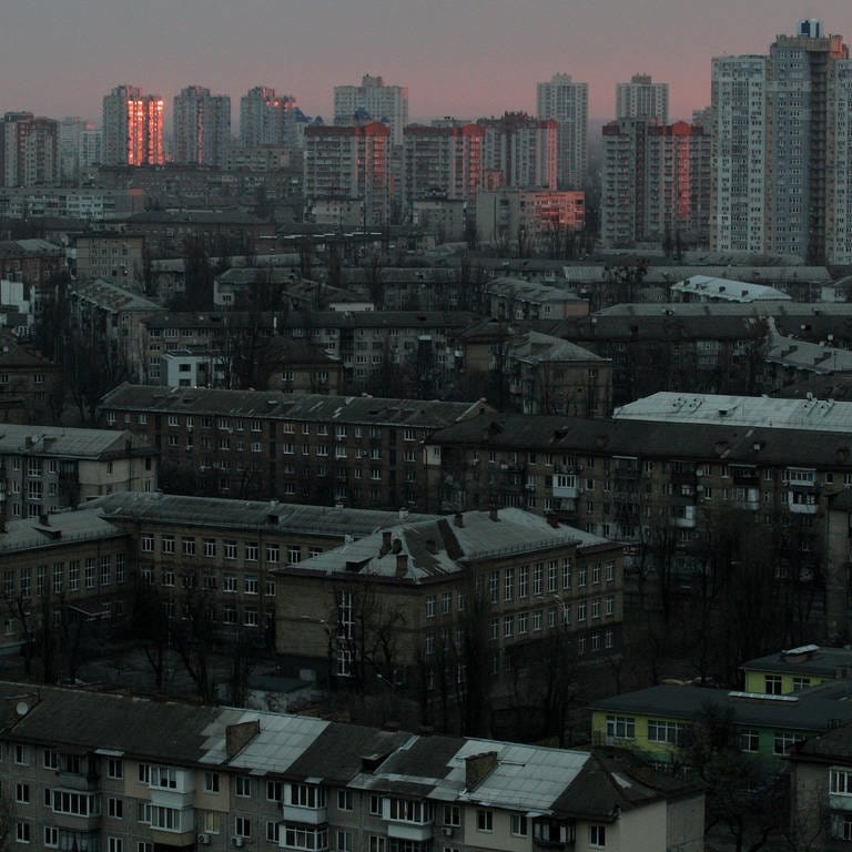 Hochhäuser in einem Wohngebiet sind in der Morgendämmerung zu sehen. Russland hat am Donnerstag, 24.02.2022, einen umfassenden Angriff auf die Ukraine gestartet und Städte und Stützpunkte mit Luftangriffen oder Granaten beschossen. (Foto: dpa Bildfunk, picture alliance/dpa/Ukrinform | -)