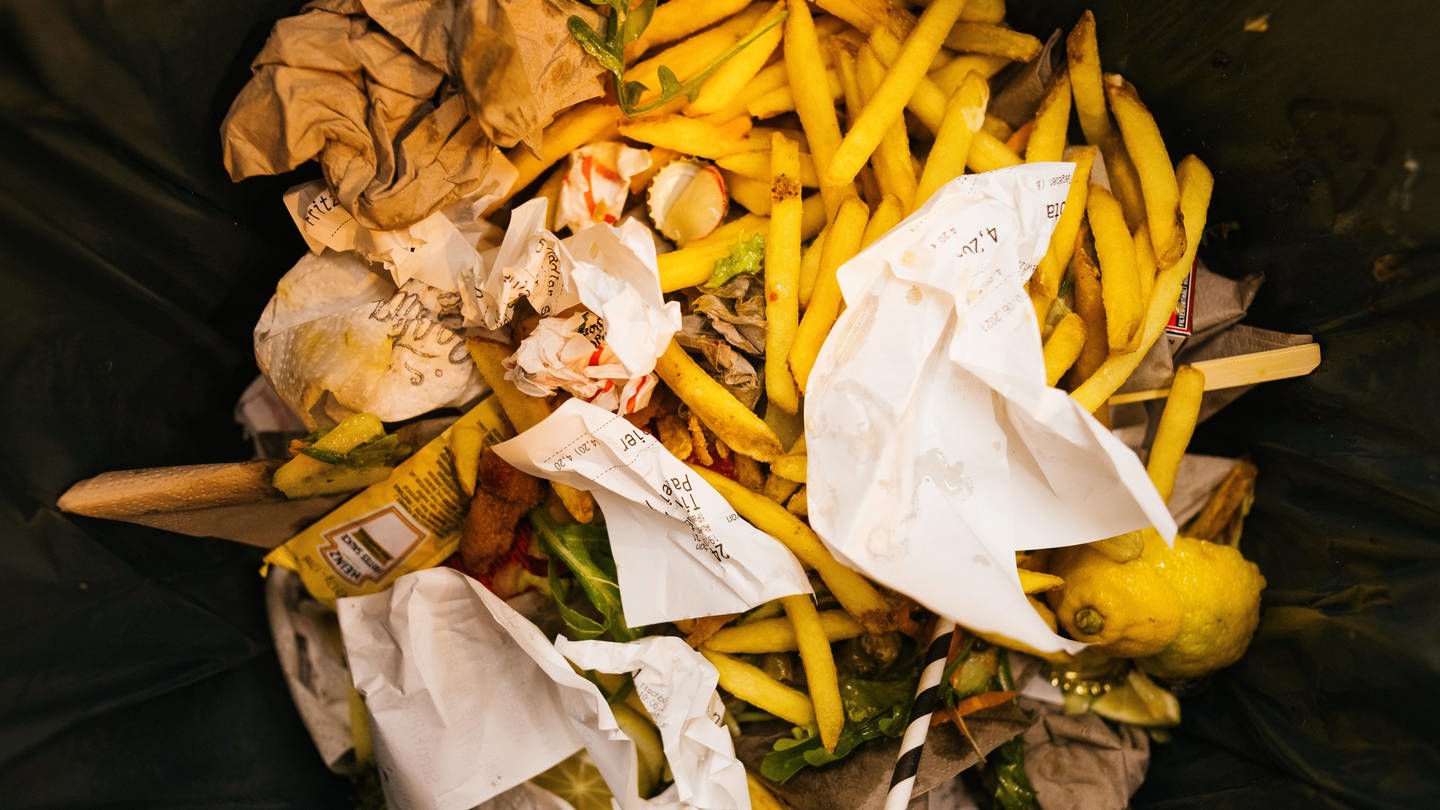Lebensmittelreste liegen in der Mülltonne eines Restaurants