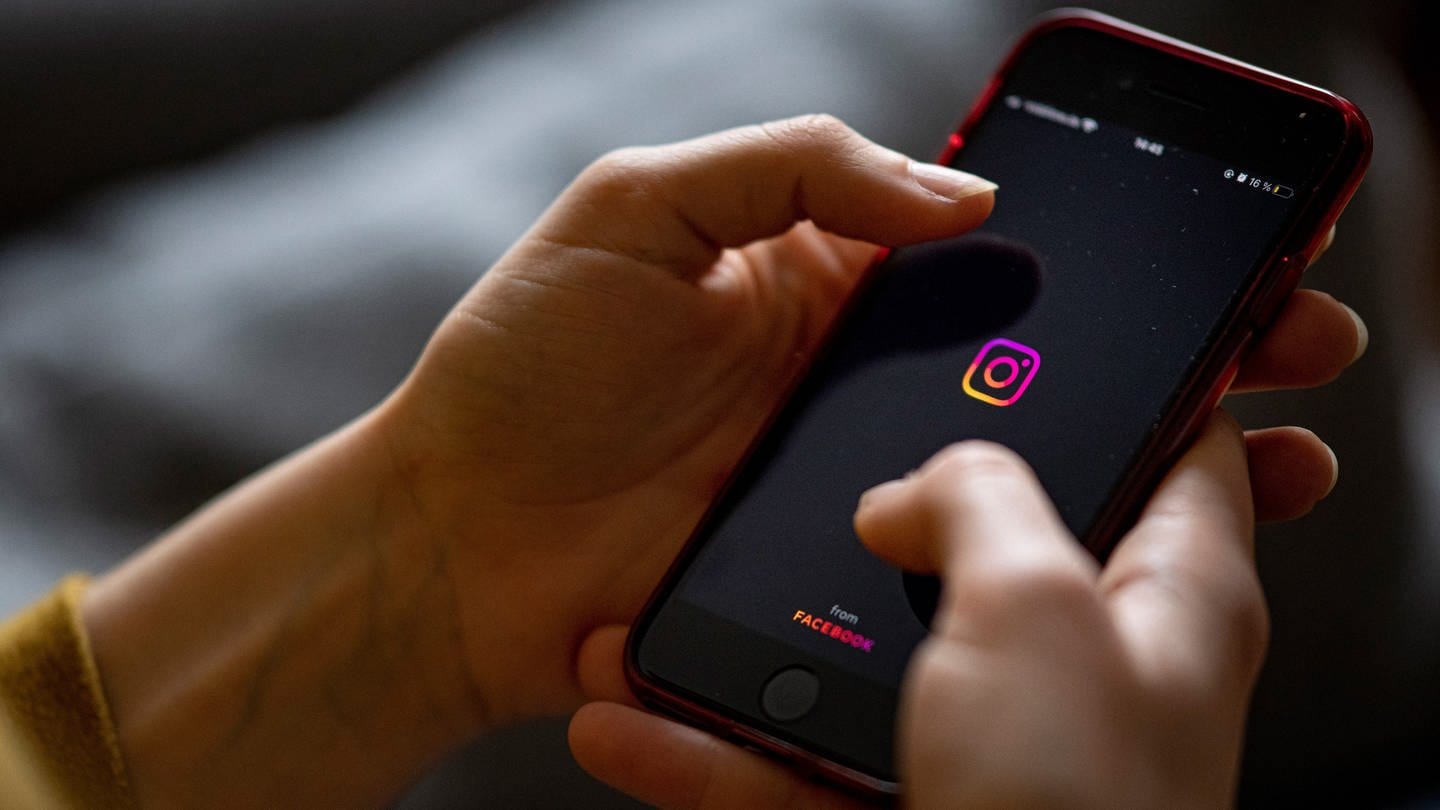 Auf dem Bildschirm eines Smartphones sieht man das Logo der App Instagram.