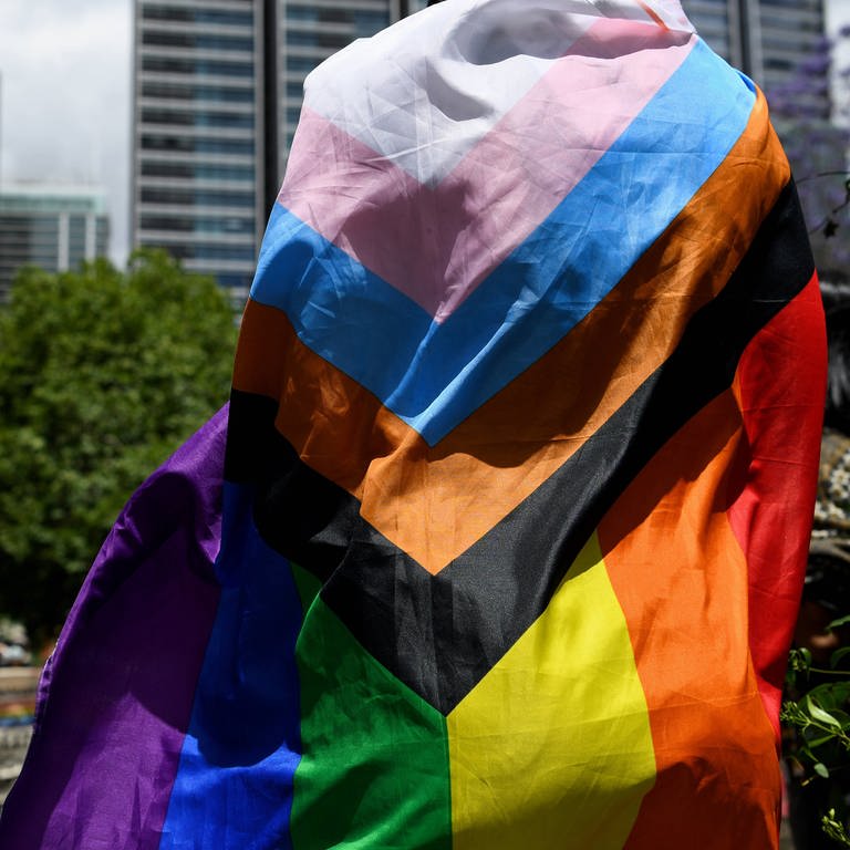 Ein Mensch trägt die Pride-Flagge. (Foto: IMAGO, IMAGO / AAP)