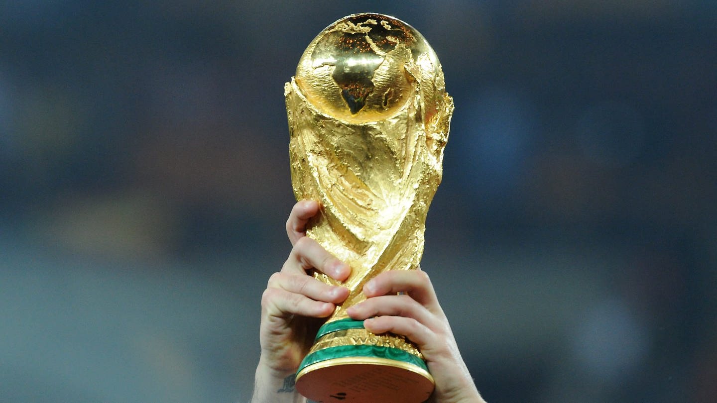 Der WM-Pokal wird von einem Spieler in die Luft gehalten