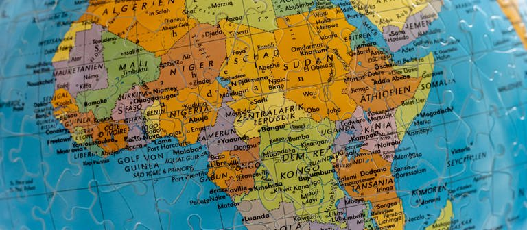 Afrika auf einem Puzzle-Globus (Foto: dpa Bildfunk, IMAGO / Arnulf Hettrich)