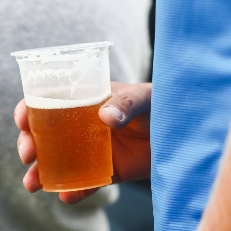 Becher mit Bier in der Hand (Foto: IMAGO, xJakubxPorzyckix / IMAGO / NurPhoto)