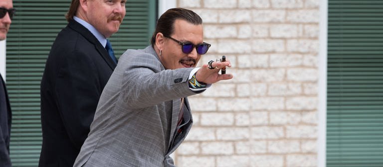 Johnny Depp winkend und lächelnd vor dem Gerichtssaal. (Foto: IMAGO, IMAGO / MediaPunch)