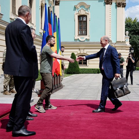 Bundeskanzler Olfa Scholz läuft in Kiew mit ausgestreckter Hand zur Begrüßung auf den ukrainischen Präsident Wolodymiyr Selenskyj zu. (Foto: dpa Bildfunk, picture alliance/dpa | Kay Nietfeld)