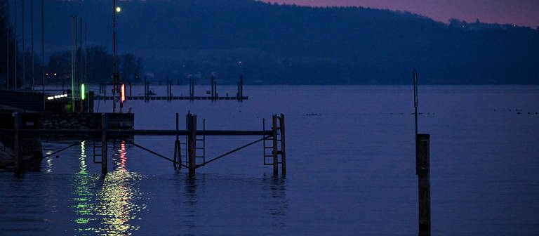 Die Beleuchtung des Yachthafens spiegelt sich zur Blauen Stunde im Bodensee. (Foto: dpa Bildfunk, picture alliance/dpa | Felix Kästle)