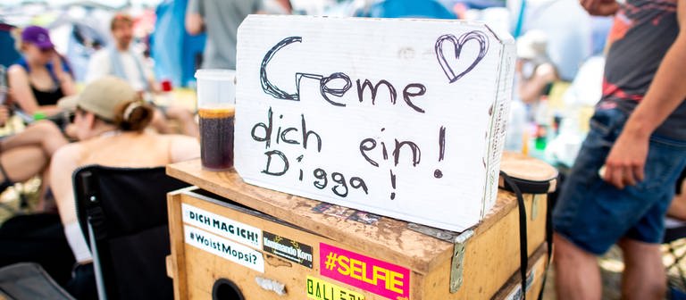 Ein Schild mit der Aufschrift „Creme dich ein! Digga!“ hängt an einem Zelt auf dem Zeltplatz des Hurricane Festivals. (Foto: dpa Bildfunk, picture alliance/dpa | Hauke-Christian Dittrich)