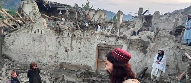 Auf diesem von der staatlichen Nachrichtenagentur Bakhtar veröffentlichten Foto betrachten Afghanen die Zerstörung durch ein Erdbeben in der ostafghanischen Provinz Paktika. (Foto: dpa Bildfunk, picture alliance/dpa/Bakhtar News Agency/AP | Uncredited)