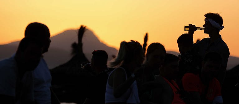Junge Leute feiern bei Sonnenuntergang am Strand von Arenal am Party-Viertel Ballermann auf Mallorca. (Foto: picture-alliance / Reportdienste, picture alliance/dpa | Clara Margais)
