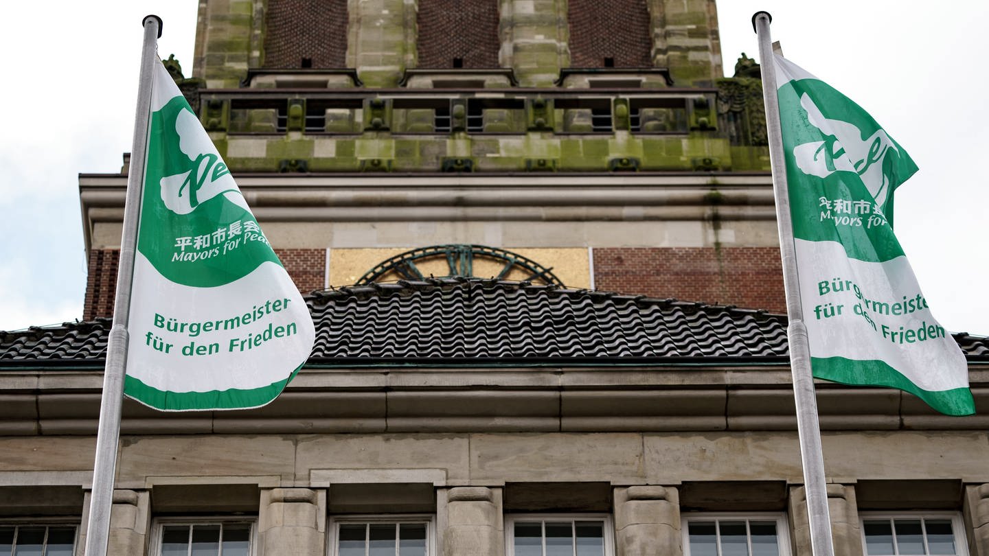 Vor dem Kieler Rathaus wehen Flaggen mit dem Schriftzug «Bürgermeister für den Frieden». (Foto: dpa Bildfunk, picture alliance/dpa | Axel Heimken)