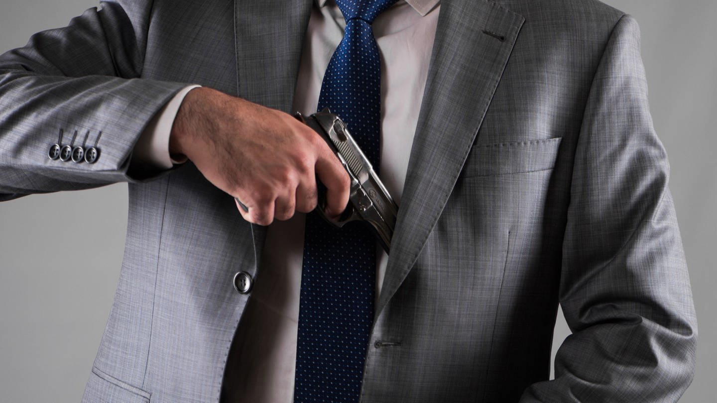 Man pulling out gun from his pocket (Foto: IMAGO, IMAGO / agefotostock)