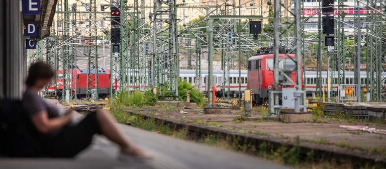 Eine Frau sitzt an einem Bahnsteig des Stuttgarter Hautpbahnhofs. Aufgrund eines Oberleitungsschadens am Hauptbahnhof ist der Zugverkehr aktuell nicht möglich. (Foto: dpa Bildfunk, picture alliance/dpa | Christoph Schmidt)