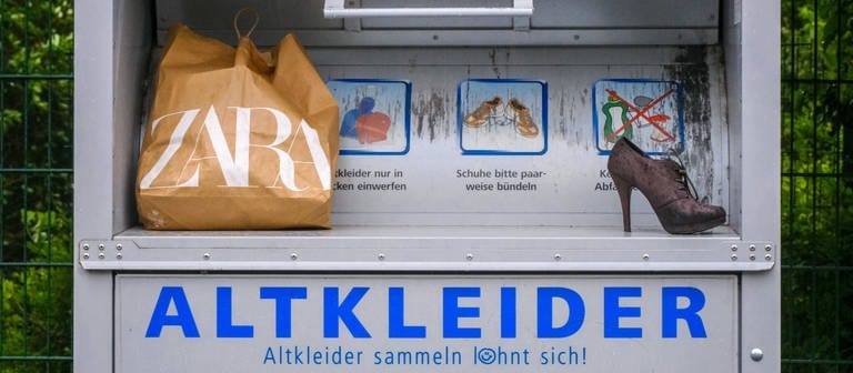 Zara-Tasche und High Heels stehen auf Altkleidercontainer. (Foto: IMAGO, IMAGO / Michael Gstettenbauer)