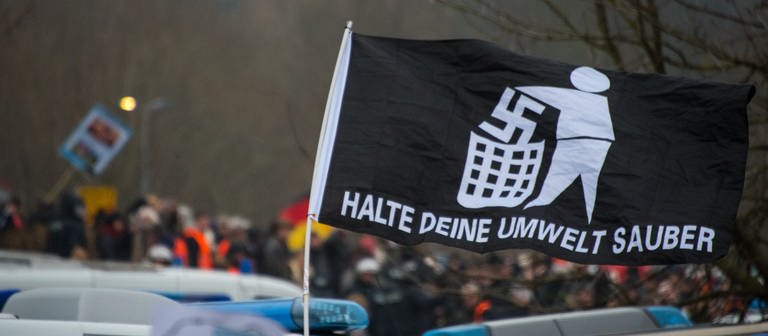 Eine Fahne mit einem Anti-Nazi Symbol wird nach oben gehalten. (Foto: picture-alliance / Reportdienste, picture alliance / Andreas Arnold/dpa | Andreas Arnold)
