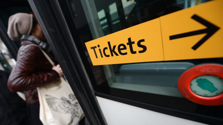 Ein Aufkleber mit der Aufschrift "Tickets" ist an einem Bus angebracht. (Foto: dpa Bildfunk, picture alliance/dpa | Arne Dedert)