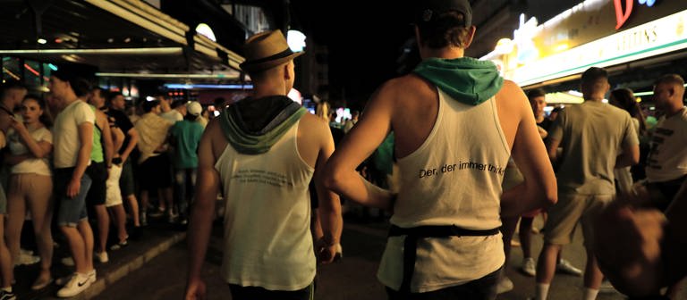 Junge Leute gehen am Abend durch die Schinkenstraße im Party-Viertel Ballermann auf Mallorca (Foto: dpa Bildfunk, picture alliance/dpa | Clara Margais)