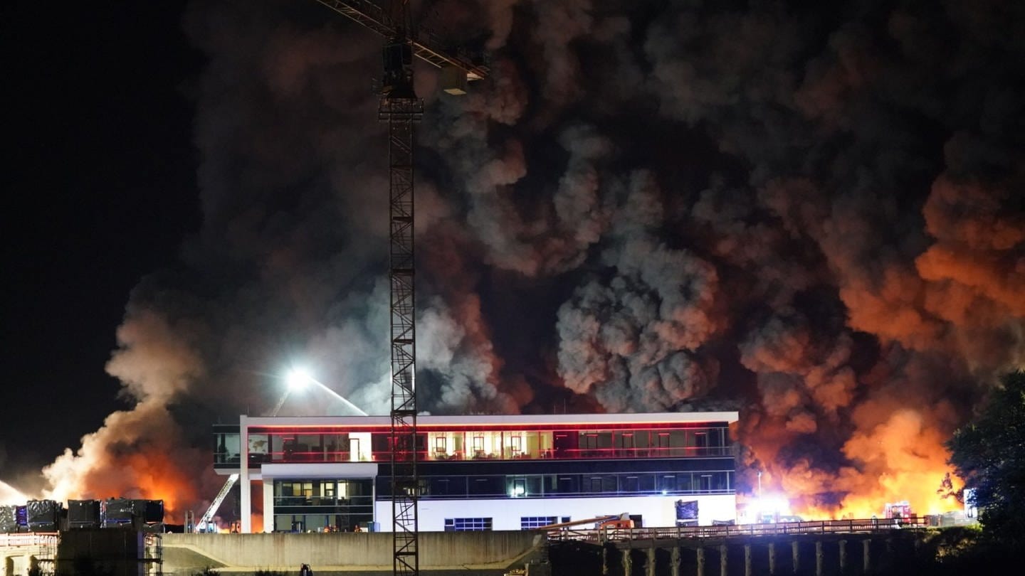 Bei einem Brand und den Löscharbeiten der Feuerwehr auf dem Gelände eines Reifengroßhändlers steigt viel Rauch auf.